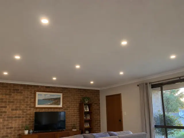 Ceiling downlights in a living room with brick feature wall and sliding glass door in Saratoga